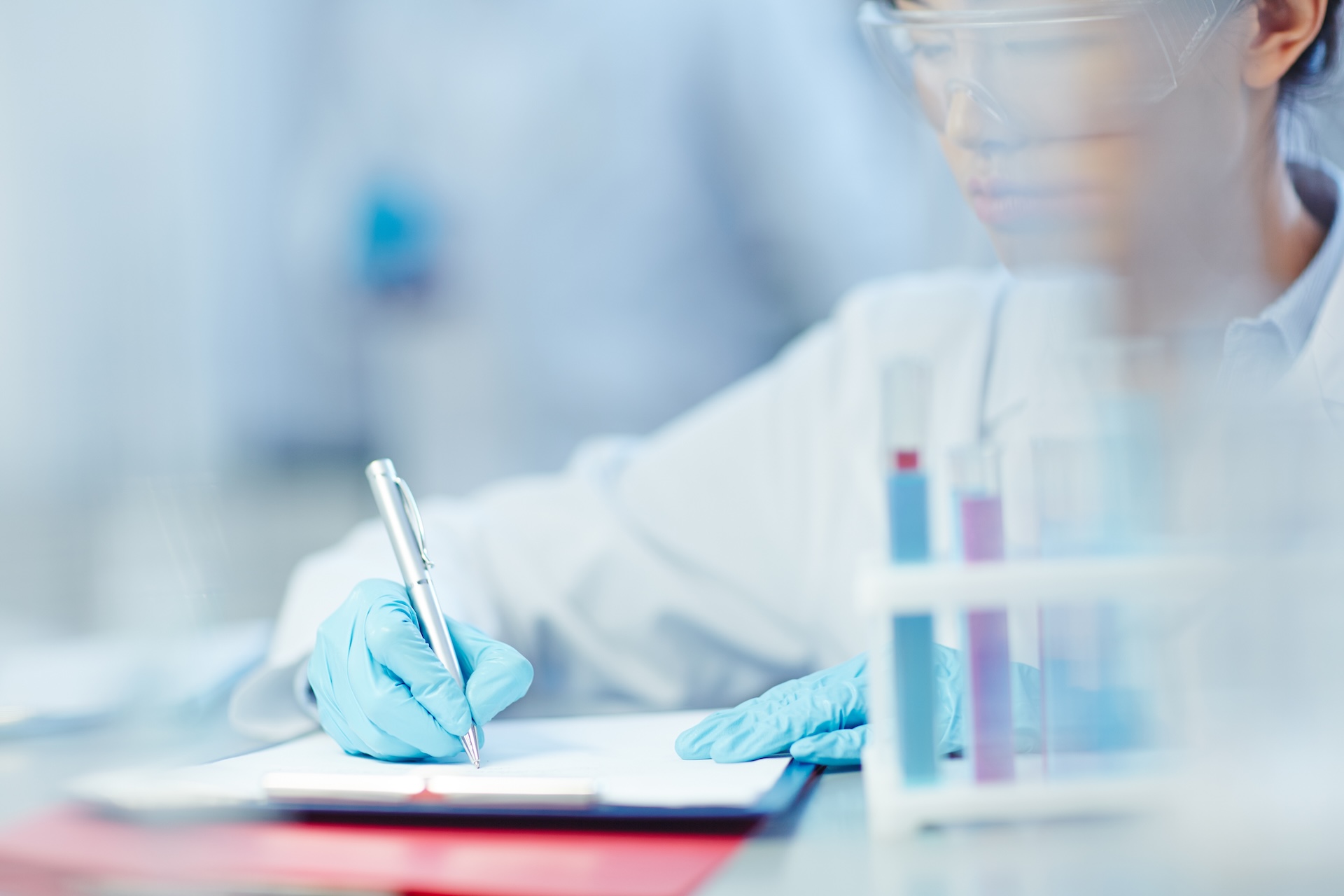 Female scientist making notes in laboratory